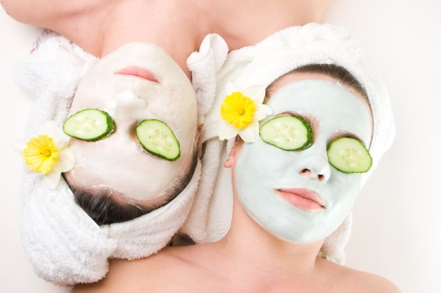 Two young female with skincare mask and cucumber on eyes
