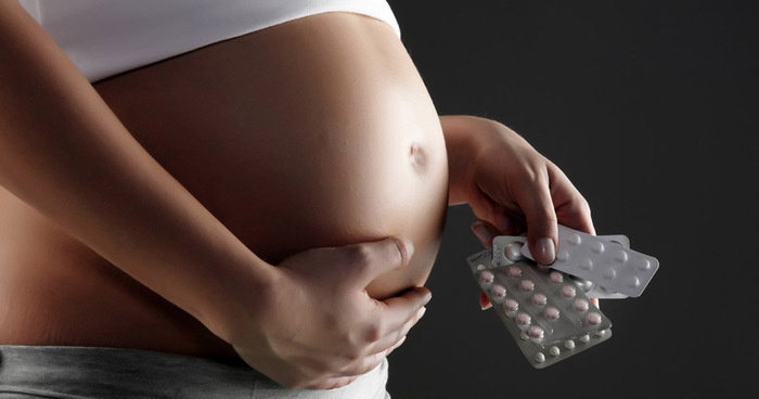 Pregnant woman holding medicine